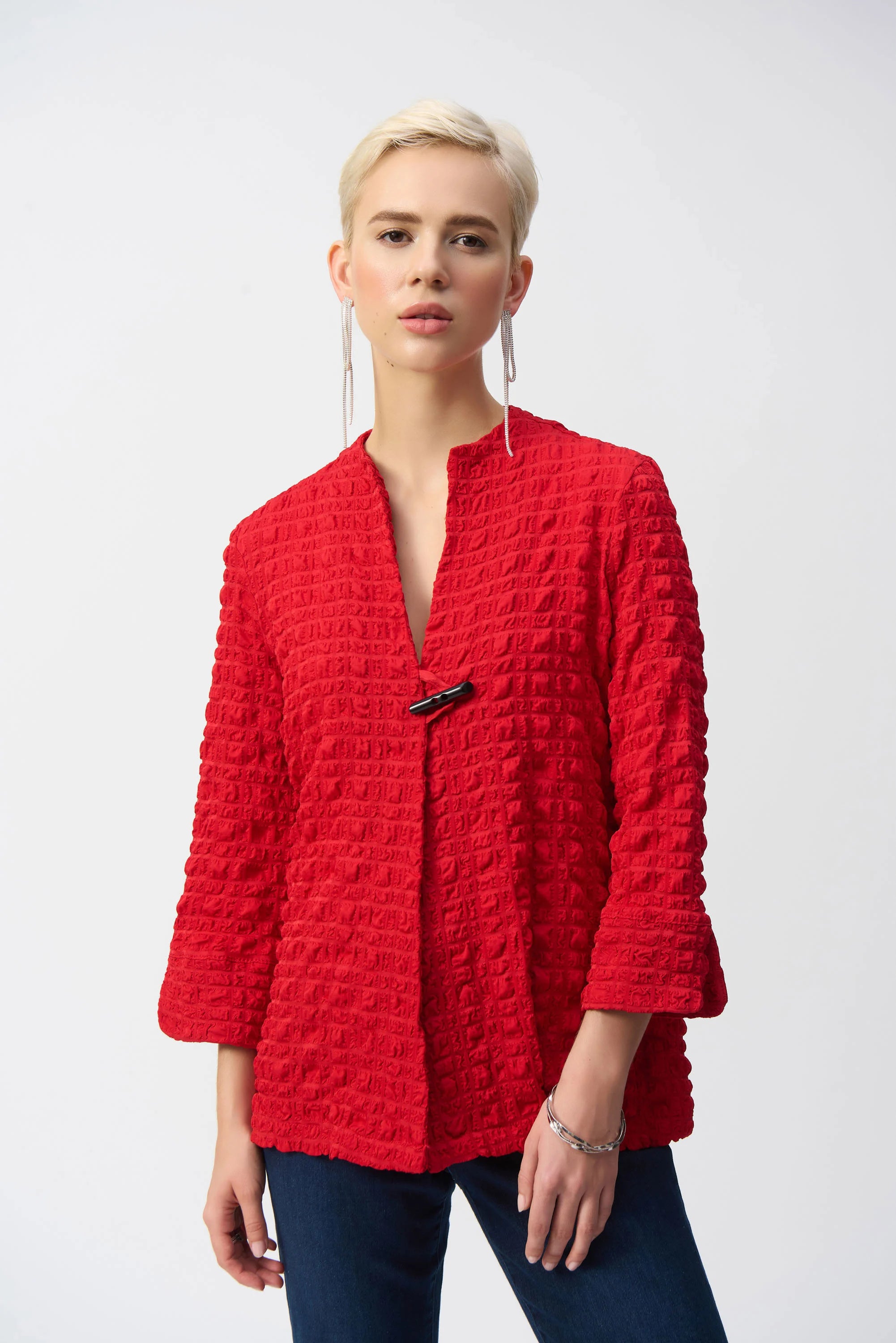 Showcase your love for bold designs with this Joseph Ribkoff bubble jacquard jacket. The three-quarter cuffed sleeves work beautifully with the garment’s chic trapeze silhouette. The crew neck and front toggle closure add a hint of flair to this unique modern design.