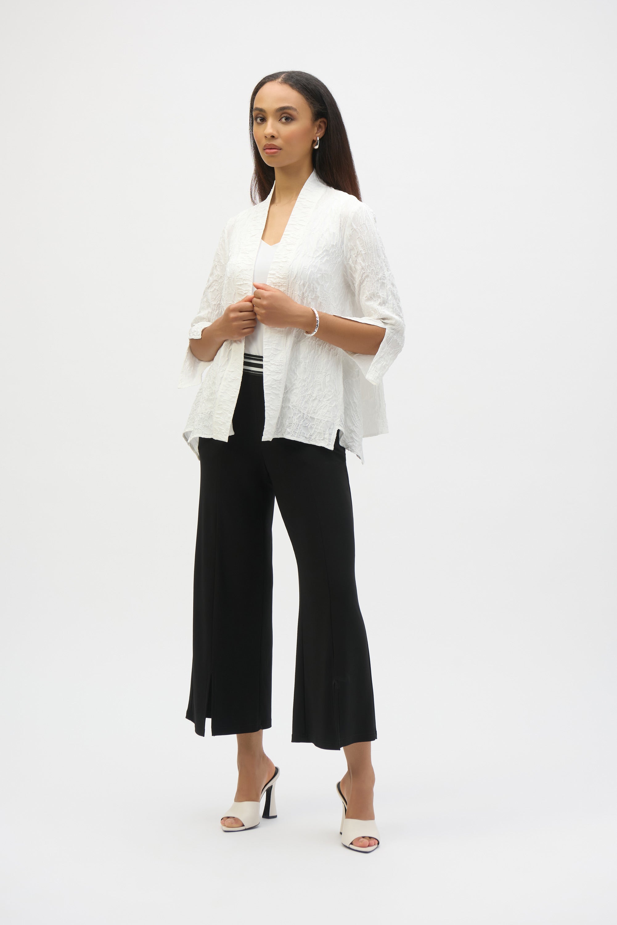 Infuse casual elegance into your everyday look with this beautiful Joseph Ribkoff cover-up. Crafted in textured jacquard fabric, the piece showcases three-quarter sleeves tailored with sleek slits, lending a refined appeal. The elongated hem at the sides elevates the garment’s straight silhouette while the side pockets add style and function to this classic wardrobe staple.