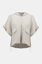 Load image into Gallery viewer, The definition of sporty chic, this Joseph Ribkoff hooded nylon jacket adds a trendy edge to your look. Featuring unexpected short dolman sleeves, front flap pockets, and a front zipper closure, it’s designed with a pleated back hem for added flair. An adjustable bungee cord lets you customize the relaxed fit to your liking.
