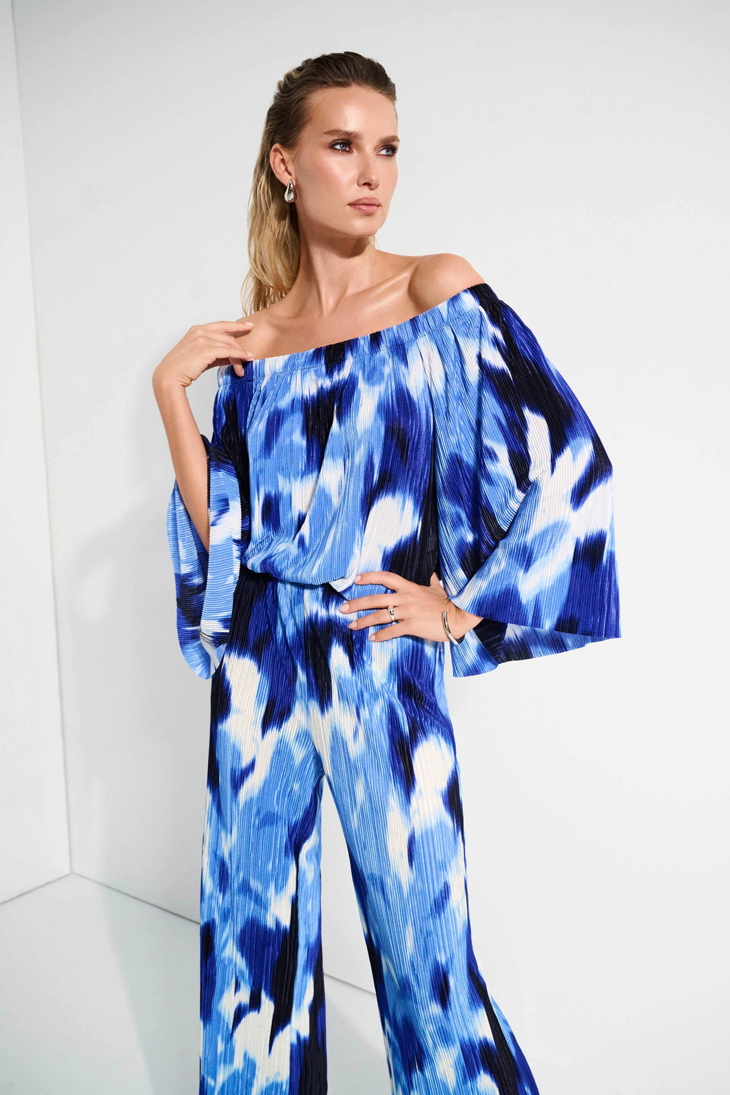 With its alluring off-shoulder neckline and striking tropical print, this Joseph Ribkoff flared top is pure vacation vibes; all that's missing is a mocktail. Three-quarter bell sleeves enhance its relaxed charm, while the pleated novelty fabric adds a subtle touch of texture.